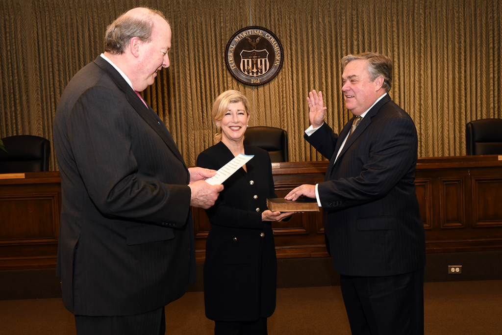 Chairman Khouri (left) administers oath of office to Commissioner Bentzel (right) who is joined by his wife, Suzanne Bentzel (center)